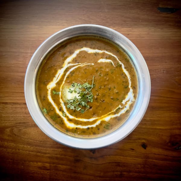 A bowl of creamy Indian Dal Makhani, garnished with fresh cilantro and a swirl of cream.