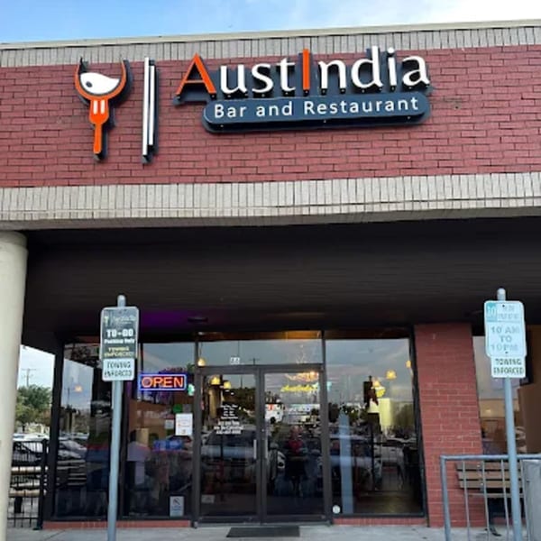 The exterior of Austindia Bar and Restaurant, with a brick facade and an "OPEN" sign in the window.